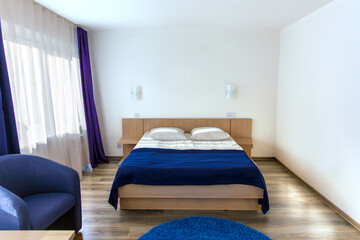 Interior of modern cozy bedroom. Double bed and wall lamps