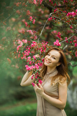 portrait of a beautiful young woman with make-up near a tree with flowers