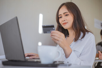 Woman holding credit card for shopping online.