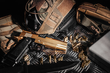 Desert eagle gun laying on metal surface with tactical gear, bullet shells and military armor...