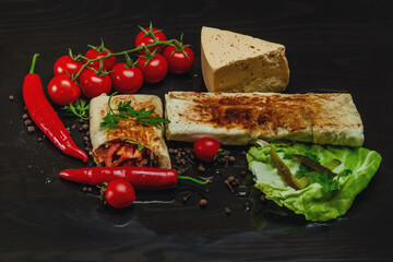 Shawarma cut in half with chicken meat on a black background. View from above. Cheese, red pepper parsley. Street Food, Fast Food, Oriental Food