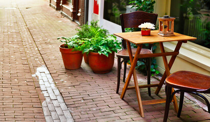 Empty European styled classic cafe table on the side walk of paved stones street