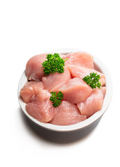 Raw chicken breast fillet chunks in clay bowl isolated on white