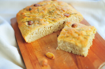 prepared and cut with a knife Focaccia with garlic and rosemary on a wooden cutting board