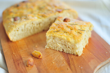 prepared and cut with a knife Focaccia with garlic and rosemary on a wooden cutting board