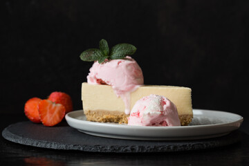  ice cream scoops with slice of cheesecake with strawberry and mint decoration. Summer food concept with copy space.