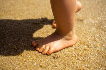toddler baby feet on the sand beach. Vacation and travel with small children concept