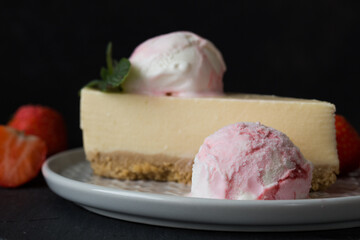  ice cream scoops with slice of cheesecake with strawberry and mint decoration. Summer food concept with copy space.