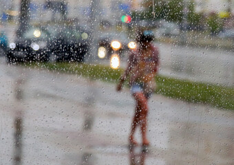 raindrops on window with person with umbrella