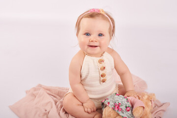 Sweet funny baby in hat with flowers. Easter greeting card, copyspace for your text. Poster for Easter holiday. Congratulations on Mother's Day. Cute baby girl 6 months wearing flower hat.