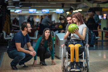 Disabled woman in a wheelchair bowling with friends