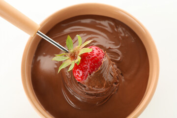 Chocolate fondue. Strawberry in chocolate and bowl on white background