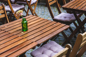 View on summer terrace of restaurant , bar, cafe with wooden tables and flowers. Beautiful terrace , outdoor summer cafe.