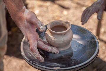 Fototapeta na wymiar Hands of a potter in a circle with clay