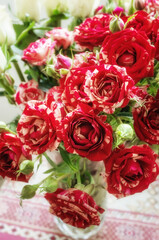 bouquet of delicate variegated white-red medium-sized roses on a light background. Background of pink roses