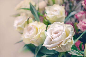 Romantic bouquet of delicate greenish roses on a light background. Close-up, copy space
