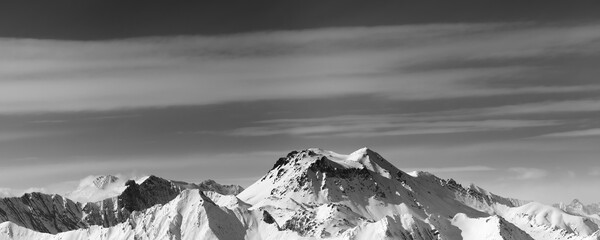 Fototapeta na wymiar Black and white panoramic view on snowy mountains in winter