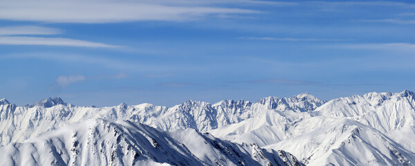 Fototapeta na wymiar Panoramic view on high snowy mountains and blue sky with clouds