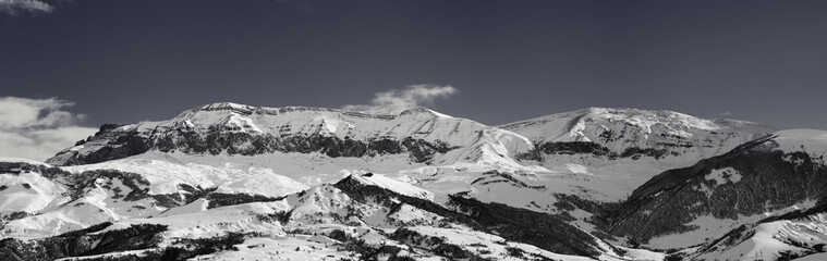 Fototapeta na wymiar Panorama of high snowy mountains and sky with clouds at sun winter day