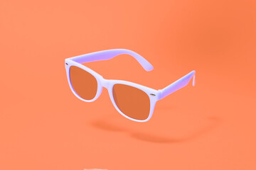 Light purple sunglasses floating above an orange background with a centre composition