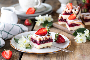 piece of tasty pie with strawberries on a white plate on ooden table.