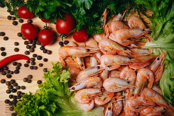 Seafood. Boiled shrimp. fresh shrimps. Boiled shrimp on a brown background, close-up. Boiled shrimp with lemon on a lettuce leaf. Beautifully laid out appetizer. Asian cuisine. 