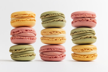 Pink, green and yellow macarons on white background