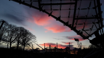 Roofing of the Olympic Park in Munich at sunset with pink clouds, Germany