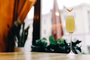 orange colored citrus alcohol cocktail on a table in a restaurant in a glass glass