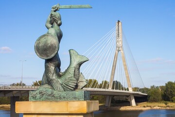 Fototapeta na wymiar Mermaid of Warsaw by the Vistula River with Swietokrzyski Bridge in the background
