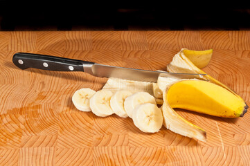 Top, front view, close distance of a ripe, local, freshly picked, banana, peeled, and sliced with a...