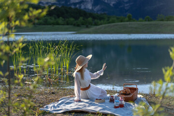 Portrait of a beautiful young woman in a white dress and hat .
