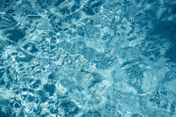 Water in swimming pool with sun reflection background