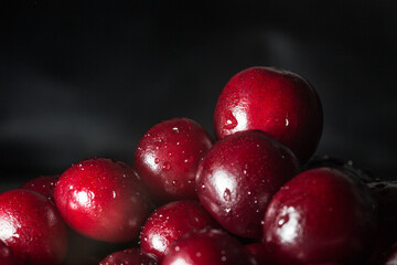 Cherries with water drops on black background