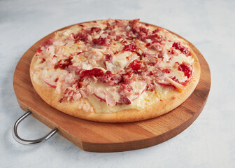 whole homemade pizza on a wooden board with blue background