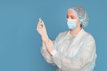 Doctor in a dressing gown, mask puts on medical gloves. Surgeon with clinical experience in healthcare, patient care