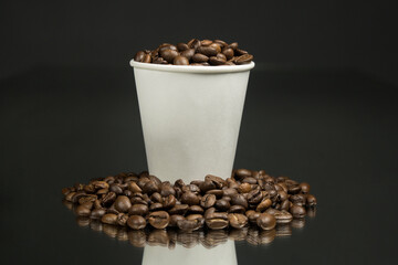 Paper cup of coffee and coffee beans on table