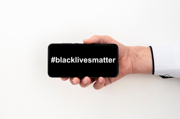 Blacklivesmatter hashtag black lives matter on a black phone screen in male hand of caucasian hand...
