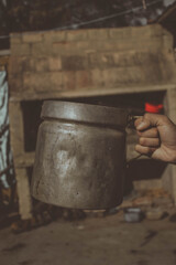 
metal milk jug held by the hand of a young teenager