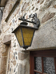 Out door lamp fixture with yellow tinted glass outside an old french home