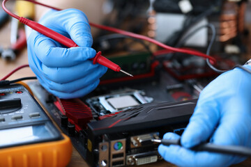 Fototapeta na wymiar Gloved hands, on table repair an electronic device