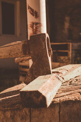 rusty ax stuck in a dry log on a sunny day