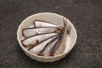 Anchovies in the bowl served basil leaves