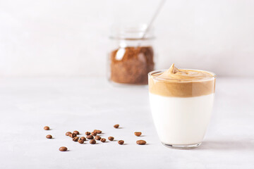 Dalgona coffee, a trendy drink. Glasses of Dalgona coffee and a can of instant coffee stand on a gray concrete table. Horizontal orientation, there is a copy space.