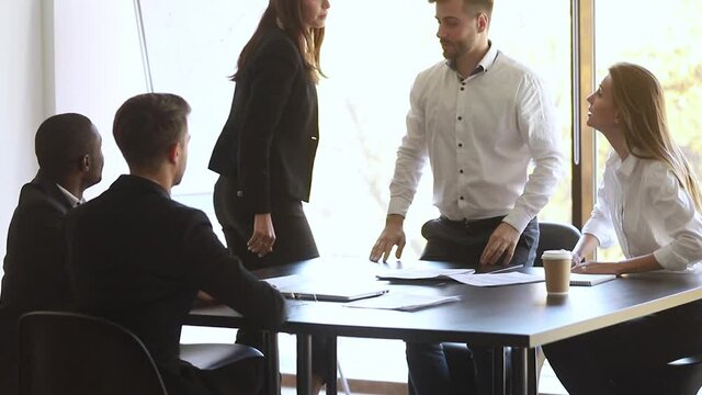 At meeting parties criticizes contract details two businesswomen throw papers express negative attitude brunette and blond stands up starting fight man trying stop a scuffle, conflicts at work concept
