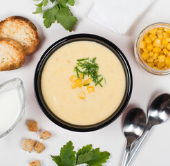 Corn soup puree in a  bowl on a light background top view