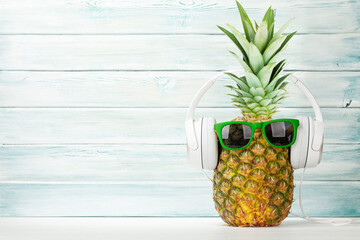 Ripe pineapple with sunglasses and headphones