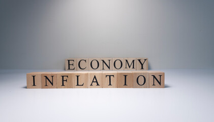 Inflation word written on wood cube with gray background.
