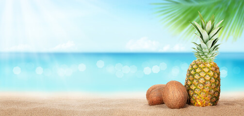 Summer tropical sea with sparkling waves, pineapple and coconuts