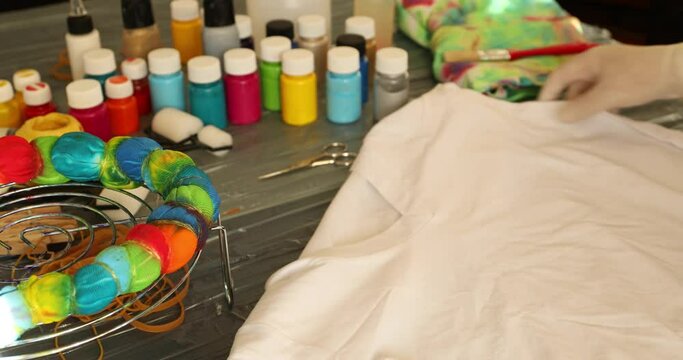 Woman applying tie dye technique to t shirt